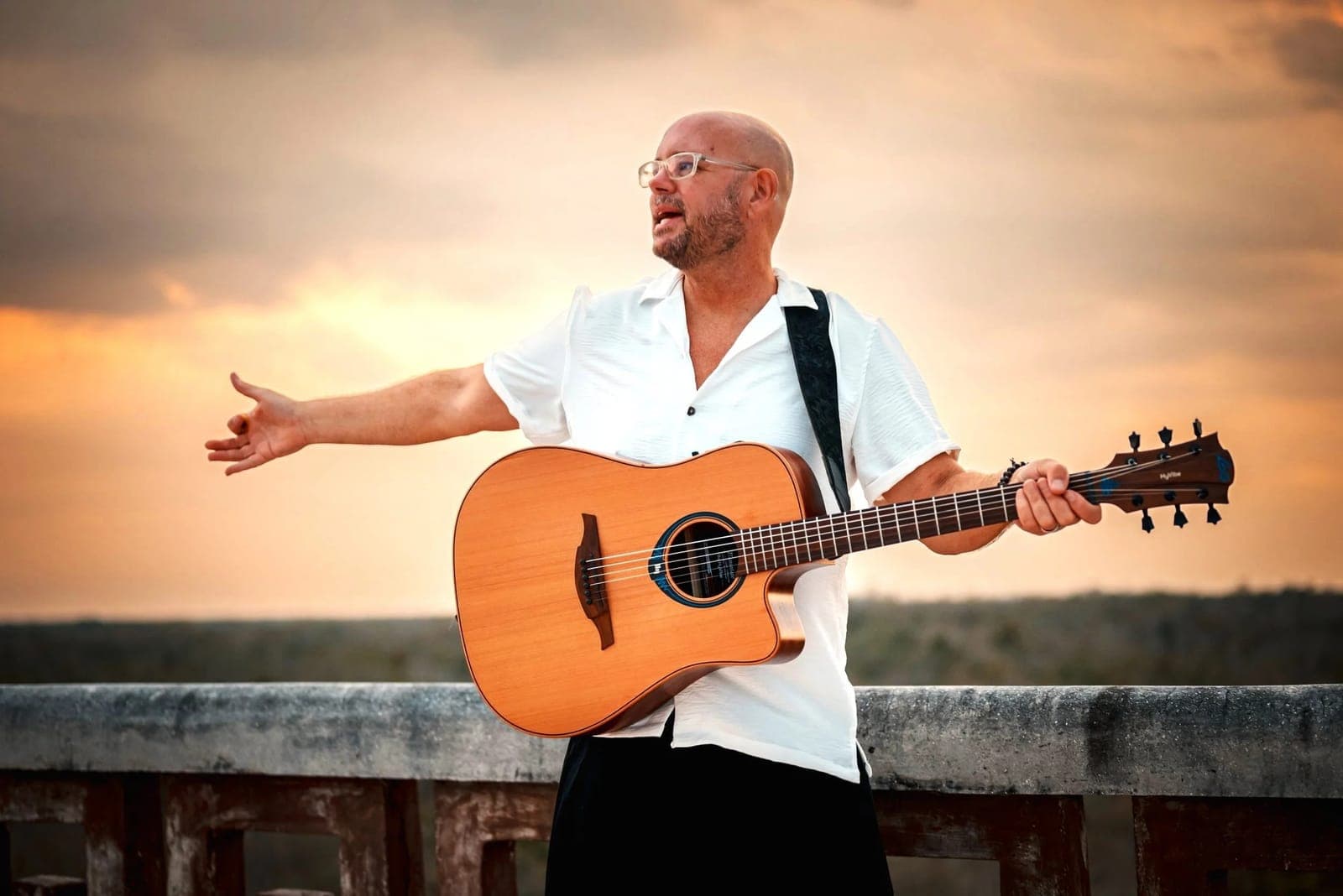 Retreat Master Bob Sima playing guitar at sunset